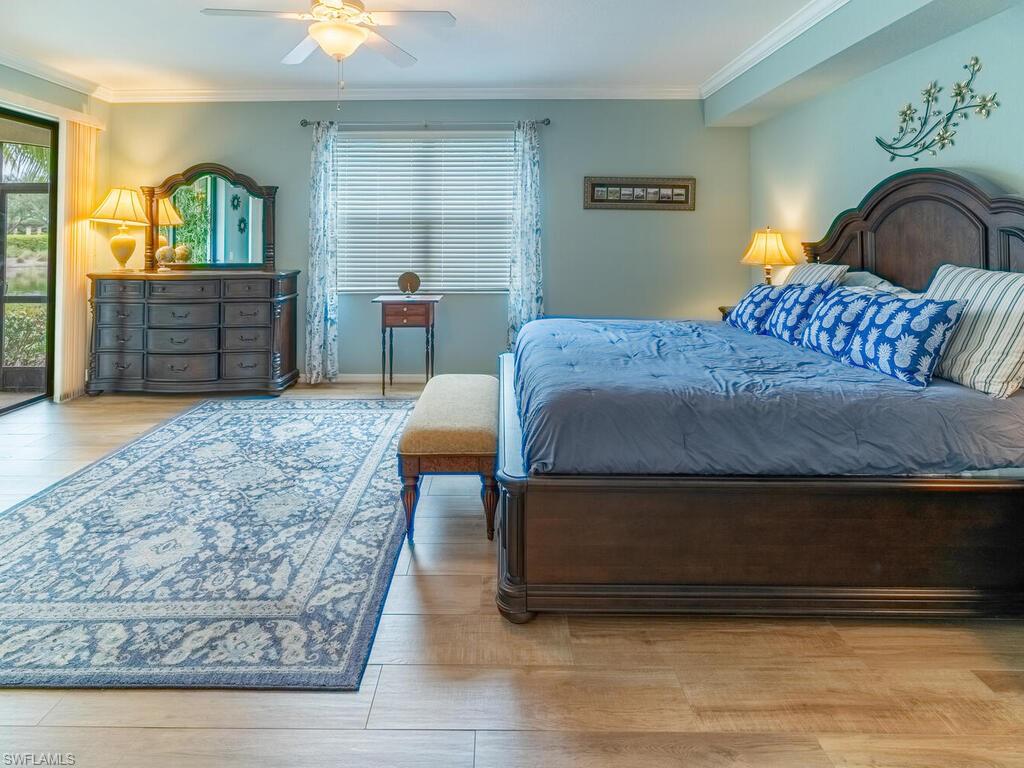 Bedroom featuring crown molding, light wood-type flooring, and ceiling fan