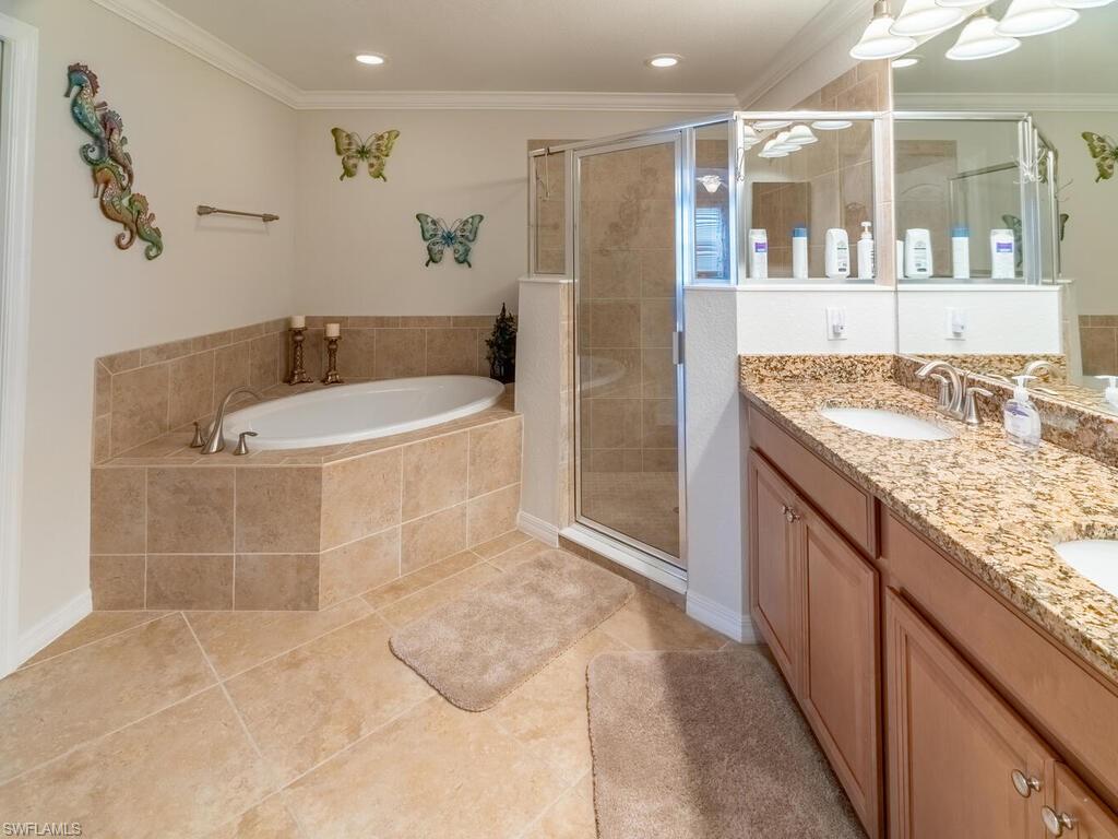 Bathroom with vanity, independent shower and bath, ornamental molding, and tile patterned flooring