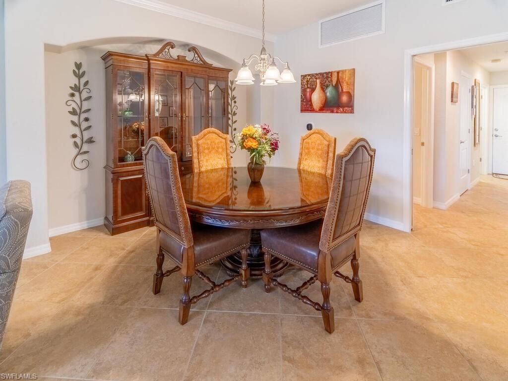 Tiled dining space with ornamental molding and a chandelier