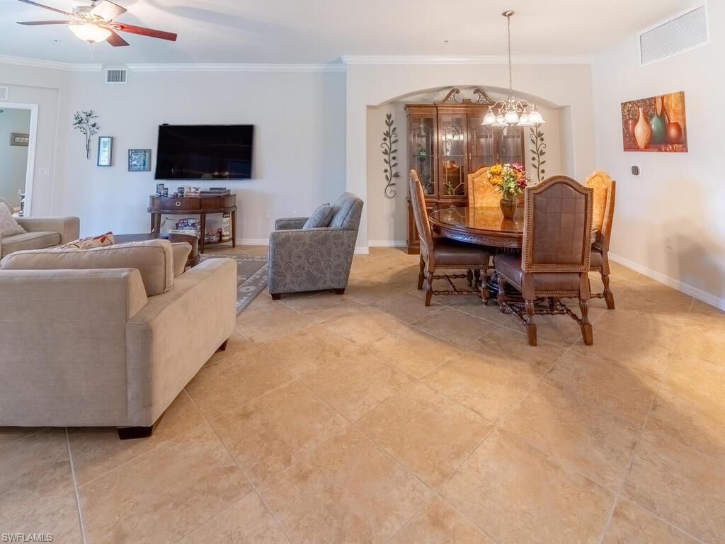 Dining space with crown molding and ceiling fan with notable chandelier