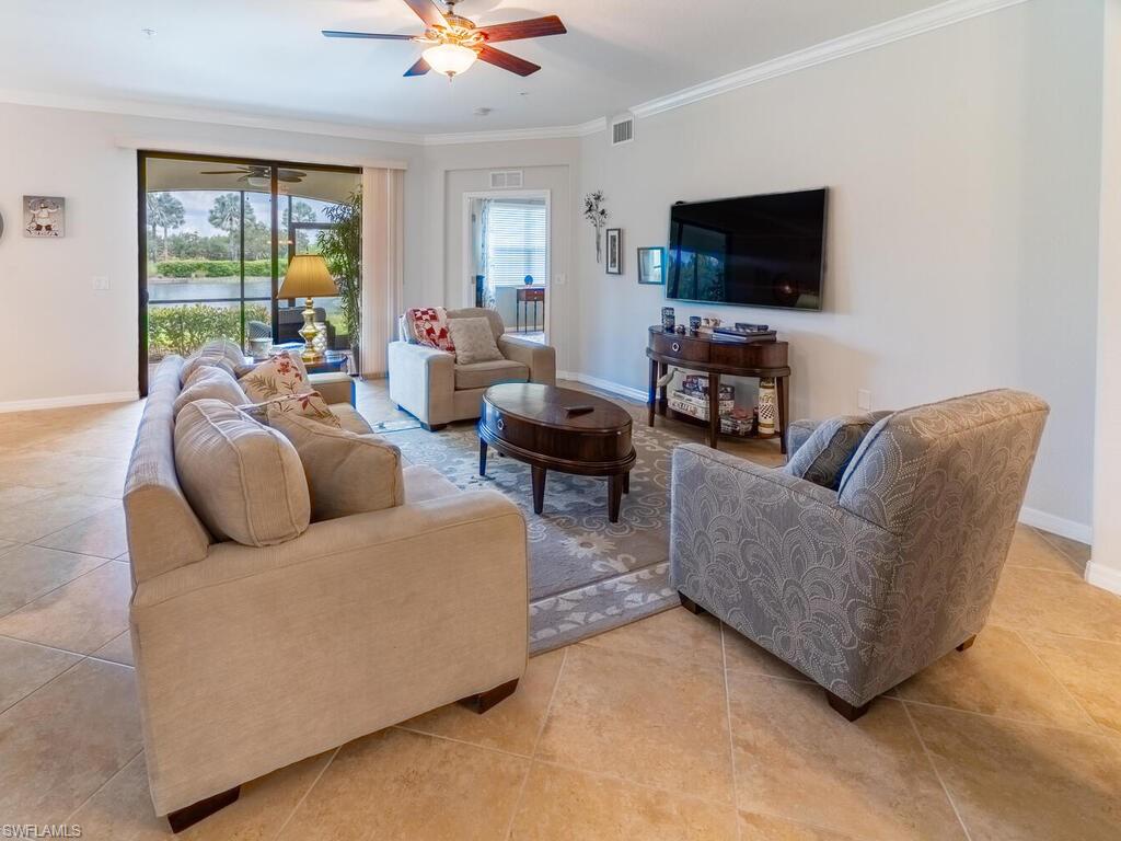 Tiled living room with crown molding and ceiling fan
