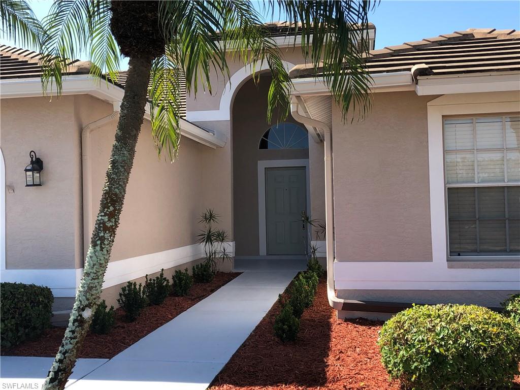 Architectural entry featuring an arched portico, transom window, and paneled entry door