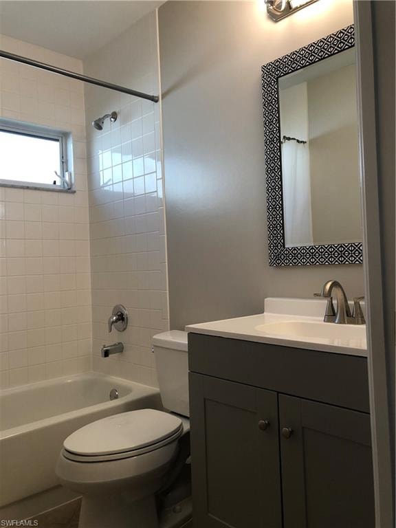 Bathroom featuring a white subway tile tub surround, white bathtub, and a window