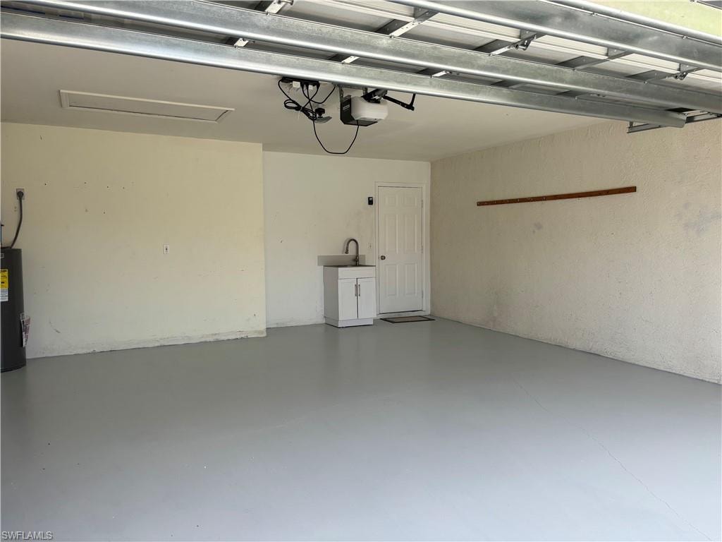 Spacious garage featuring a light gray floor coating, white interior walls, and an overhead garage door mechanism