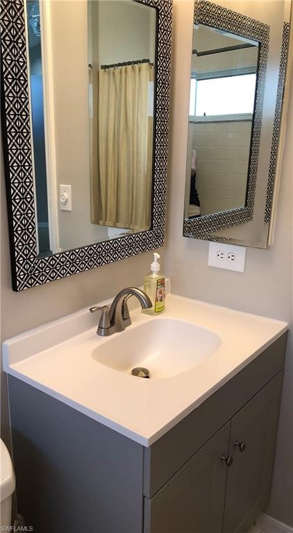 Vanity with integrated sink, light countertop, and a brushed nickel faucet