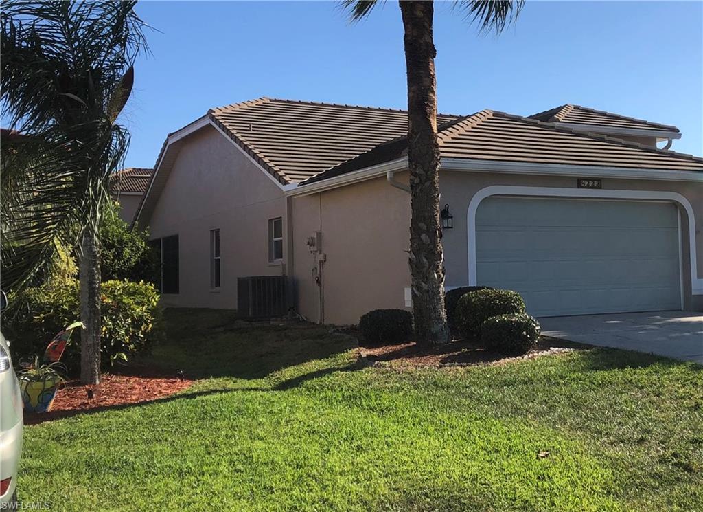 Stucco exterior featuring a tiled roof and an integrated garage with an arched surround