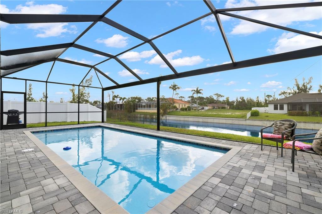View of pool with a patio and glass enclosure