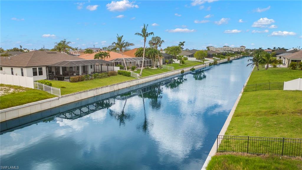 View of pool with a yard and a water view