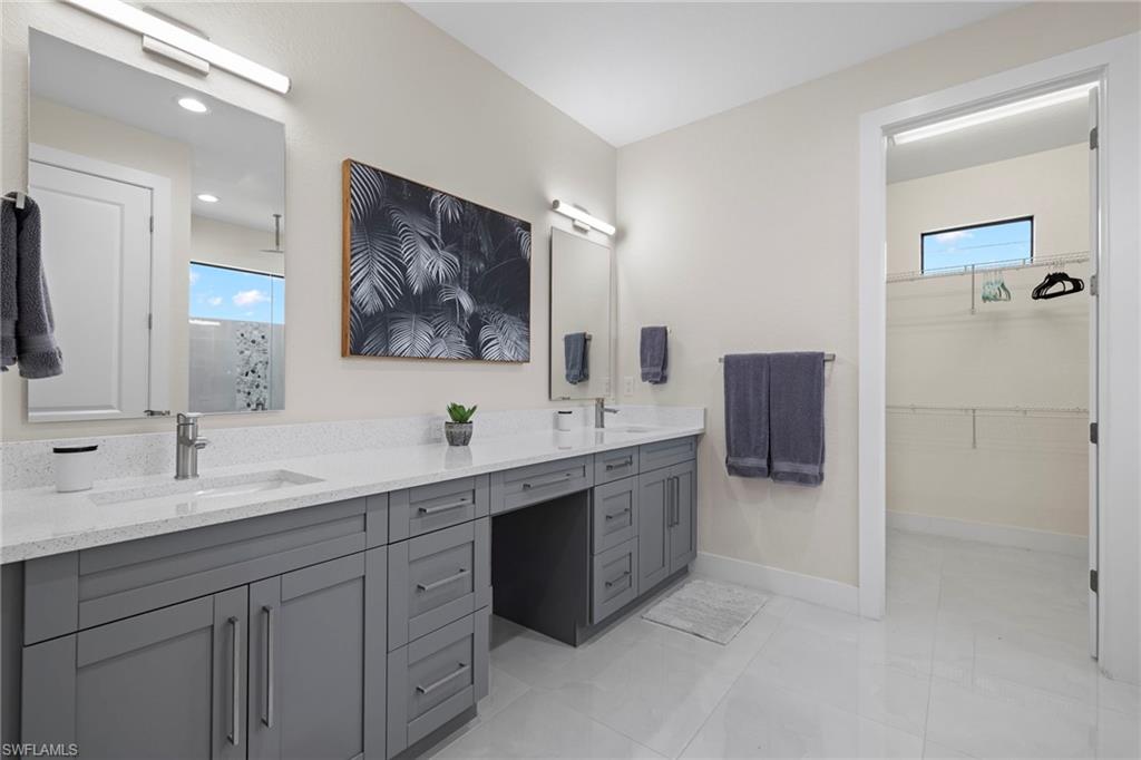 Bathroom featuring a shower with door, tile patterned flooring, and vanity