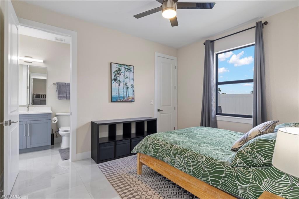 Bedroom featuring ceiling fan, connected bathroom, sink, and light tile patterned floors