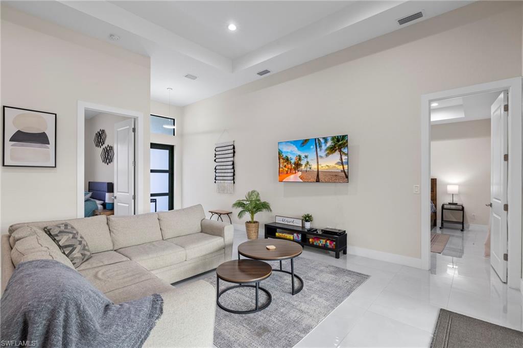 Tiled living room featuring a raised ceiling