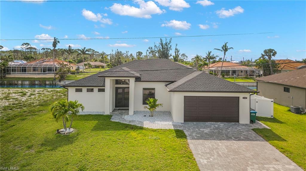 View of front of property with a front yard, central AC, a garage, and a lanai