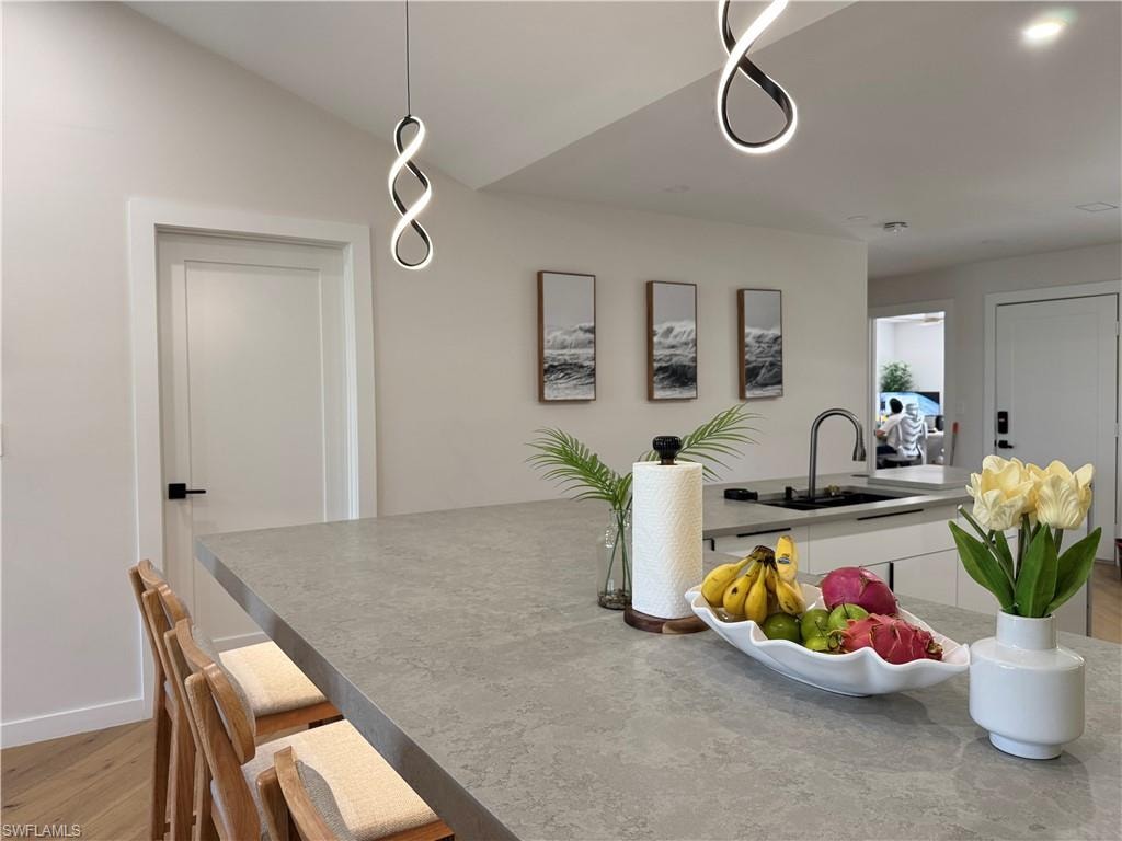Dining room with lofted ceiling, light wood finished floors, and baseboards