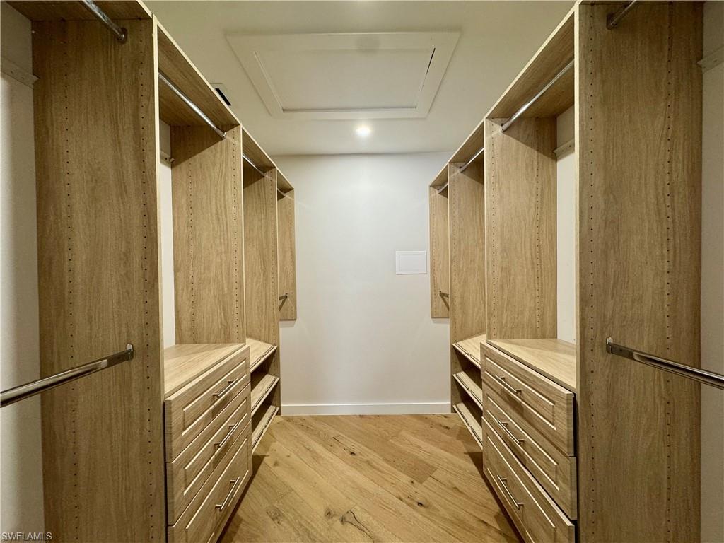 Walk in closet featuring light wood-style flooring and attic access