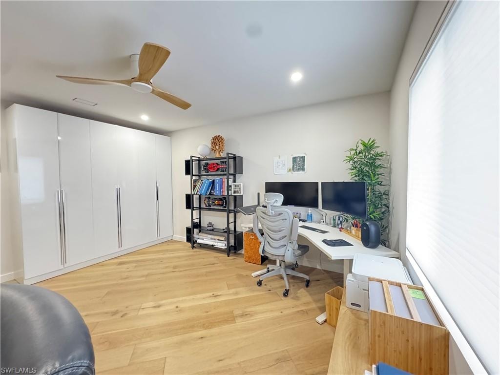 Office space with light wood finished floors, a ceiling fan, and recessed lighting