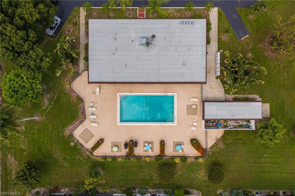 Clubhouse and community swimming pool with seating, tables and perimeter fencing