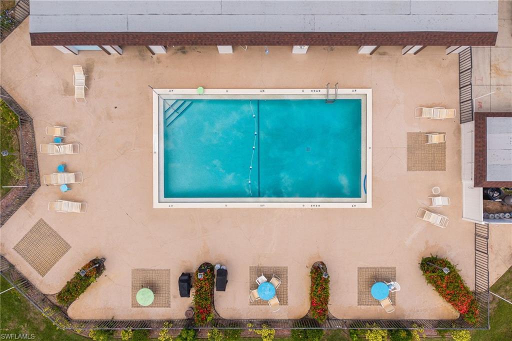 Community swimming pool with seating, tables and perimeter fencing