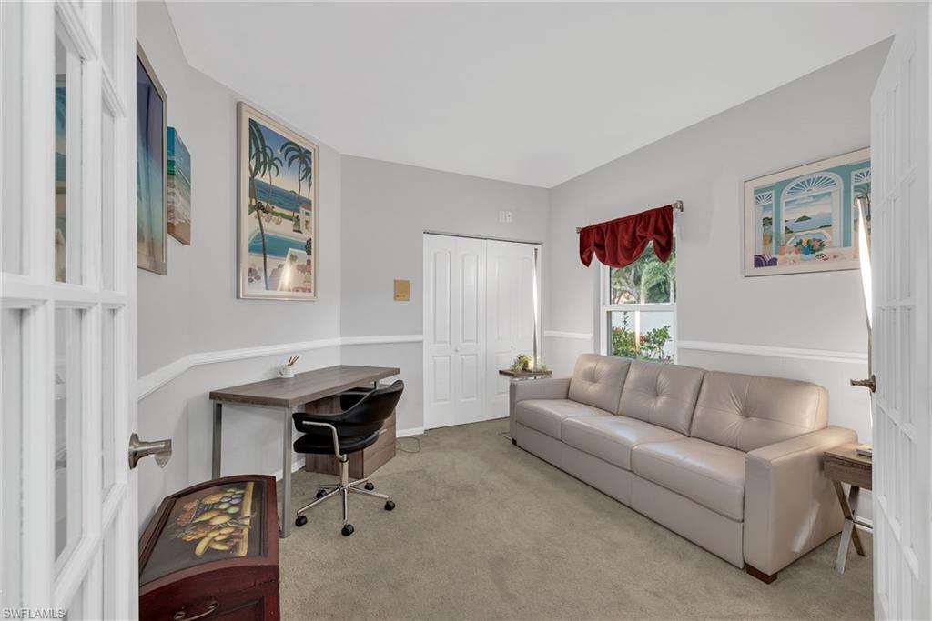 Room featuring light gray walls with white chair rail molding, a window with red valance, and a bi-fold closet door