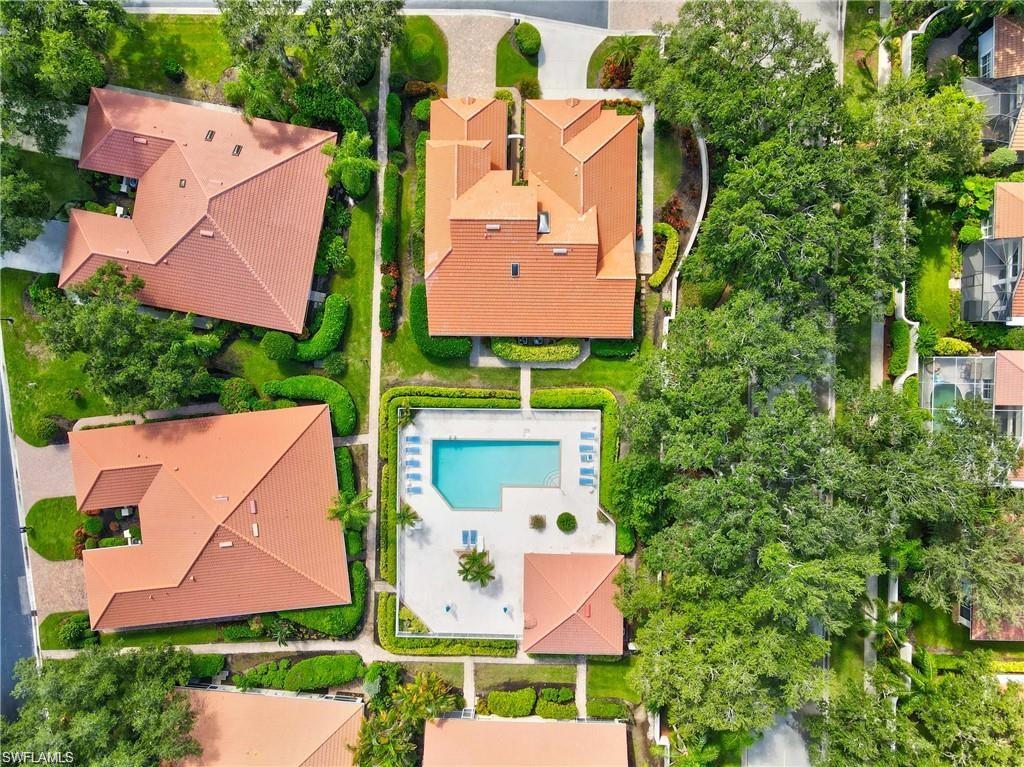 Aerial view of a residential community featuring tile roofs and lush landscaping