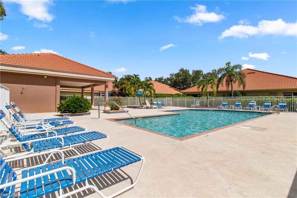 Outdoor swimming pool with concrete decking and surrounding white fencing