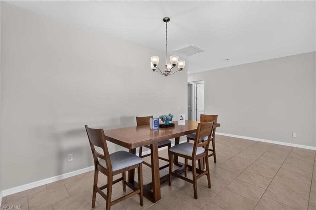 Dining area featuring a contemporary chandelier, neutral wall paint, and ceramic tile flooring