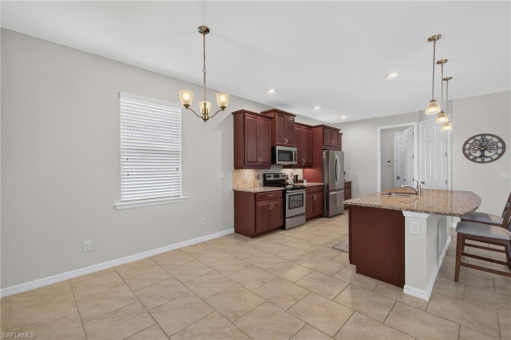 Kitchen with tile flooring, dark wood cabinetry, and stainless steel appliances