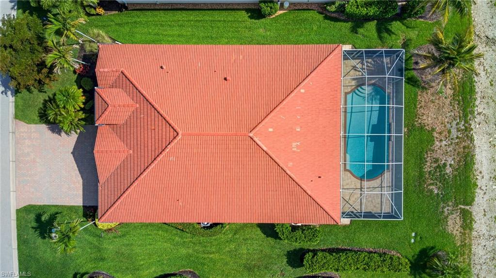 Red tile roof architecture with a screened-in swimming pool