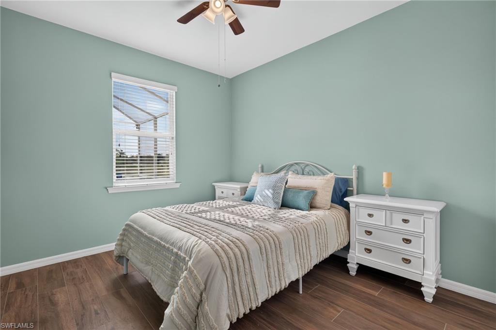 Spacious room featuring wood-finish flooring, a ceiling fan, and a window with horizontal blinds