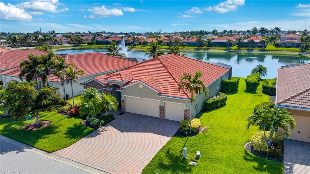 Mediterranean-style residence featuring a tile roof, an attached two-car garage, and a paver driveway