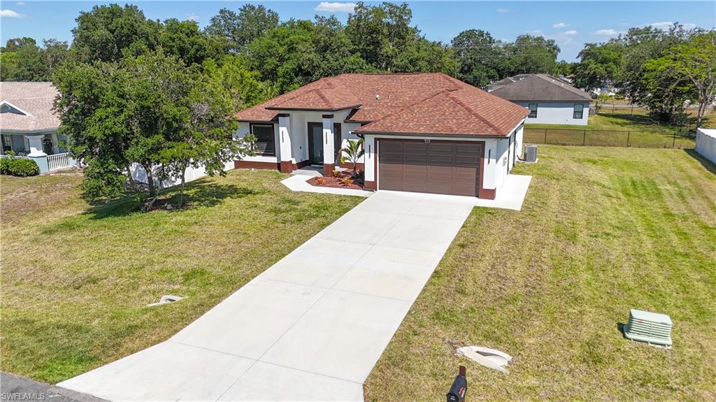 Contemporary single-story residence featuring a brown shingle roof, white stucco exterior, and dark brown trim accents