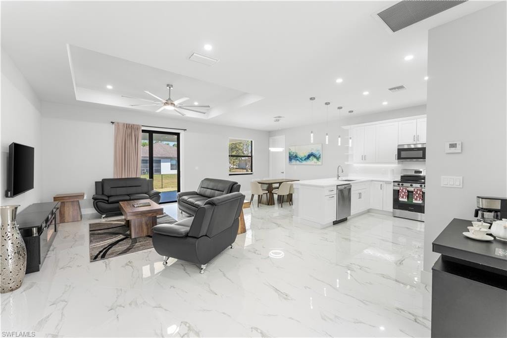 Open-concept living space featuring high ceilings, recessed lighting, and large format polished tile flooring