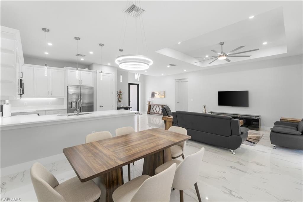 Open-concept living space featuring a contemporary kitchen, dining area, and living room