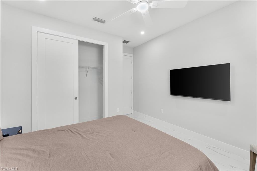 Recessed lighting, ceiling fan, and light-toned flooring