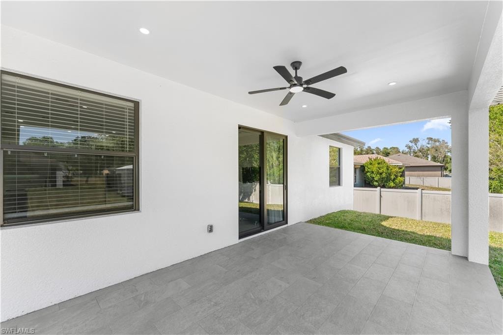 Covered patio featuring recessed lighting and a ceiling fan, grey-toned tile flooring, and a sliding glass door