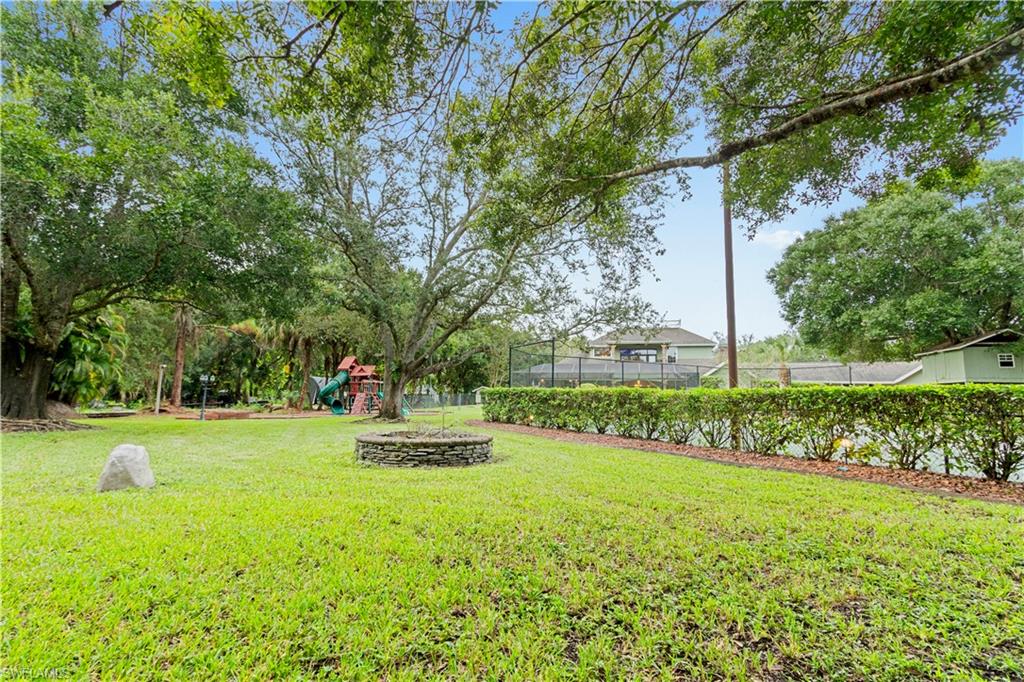 Expansive green lawn with mature trees providing canopy