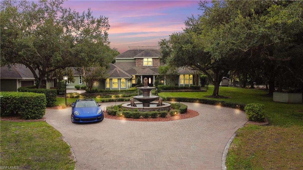 Expansive paved circular driveway with a central tiered fountain