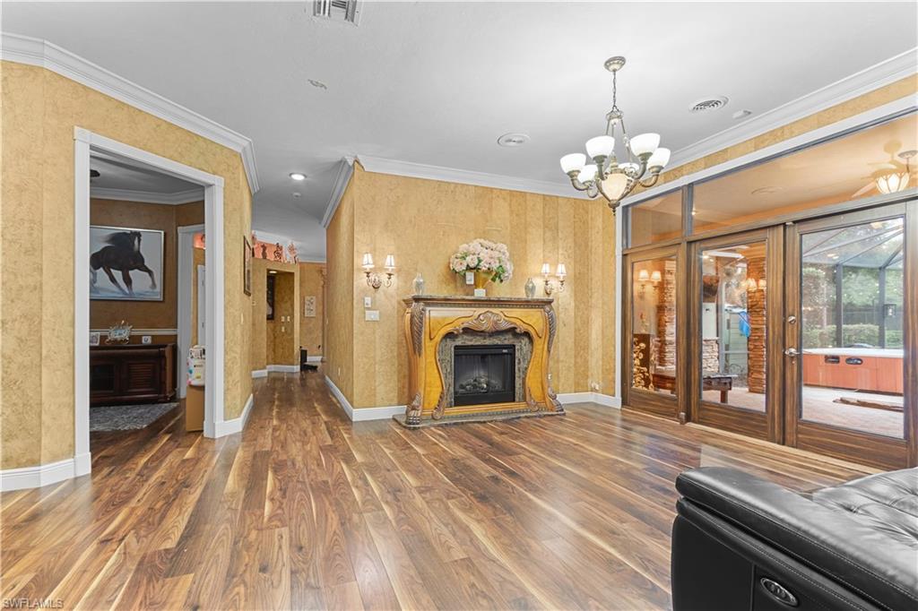 Spacious room featuring wood-finish flooring, an ornate fireplace, and textured wall coverings