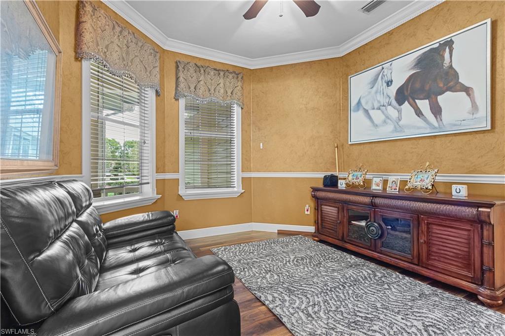 Room featuring wood-finish flooring, textured wall finish, and white crown molding