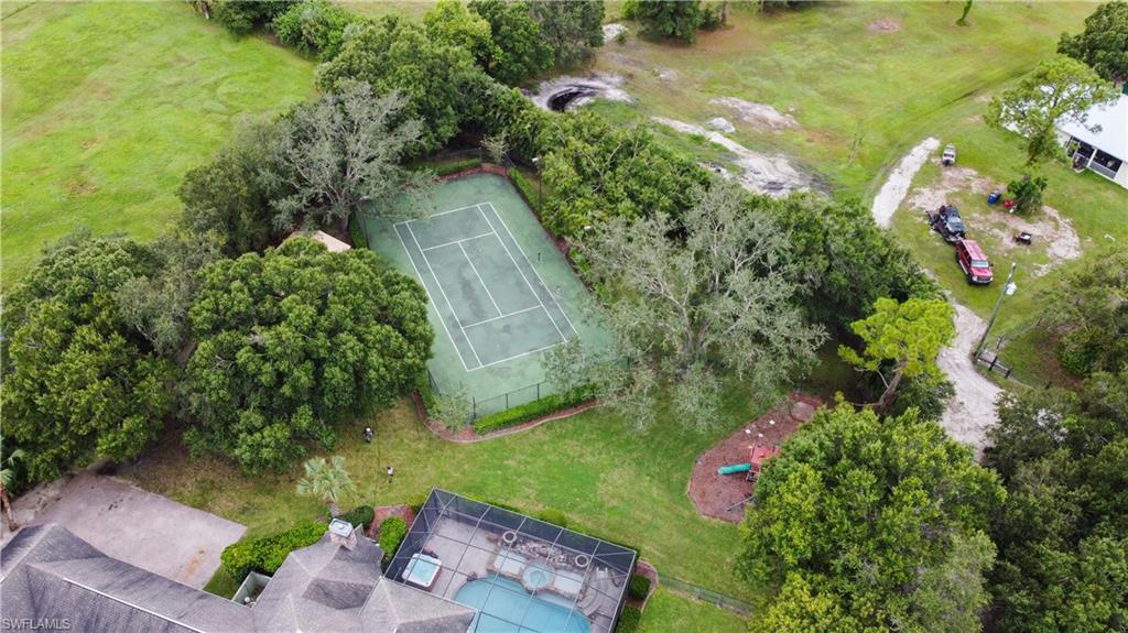 Private tennis court surrounded by mature trees
