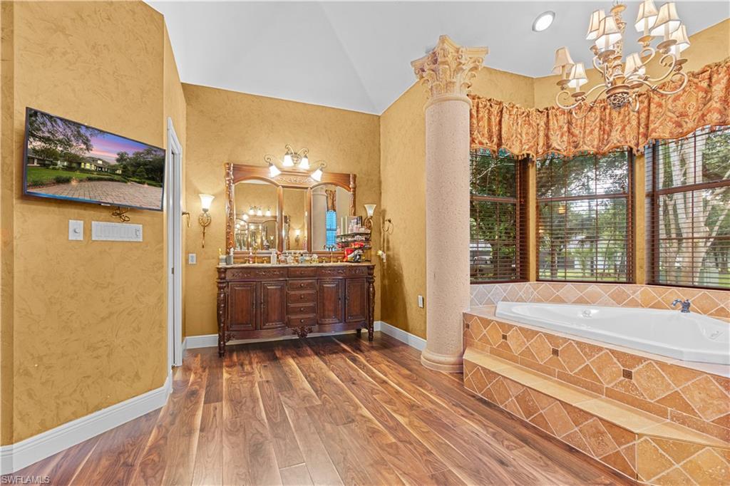 Soaking tub with patterned tile surround and an ornate chandelier