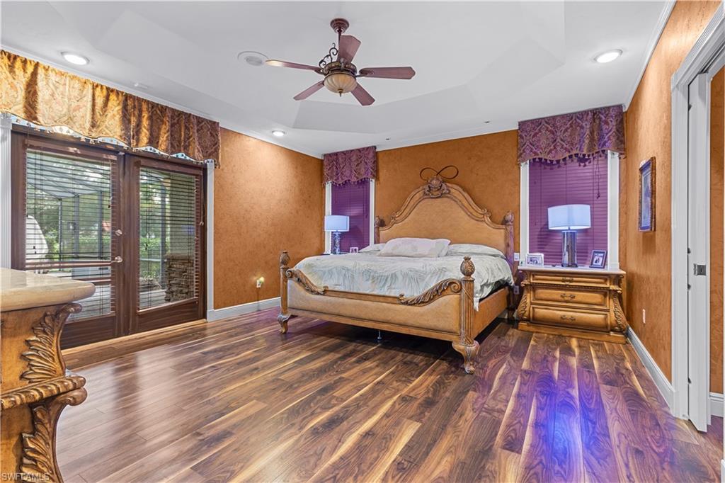 Wood-finish flooring with tray ceiling and recessed lighting