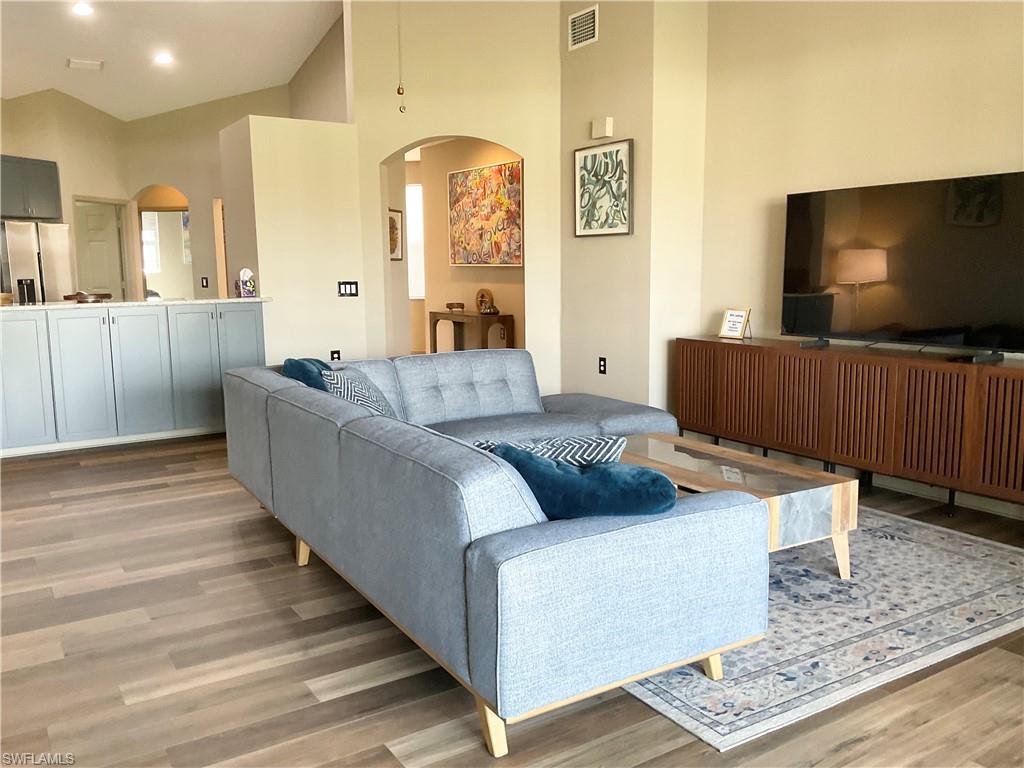 Living room with high vaulted ceiling and large screen smart TV