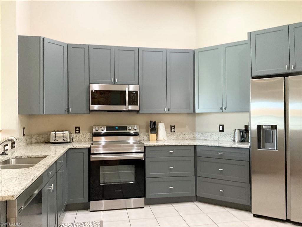 Kitchen stainless appliances and gray cabinets