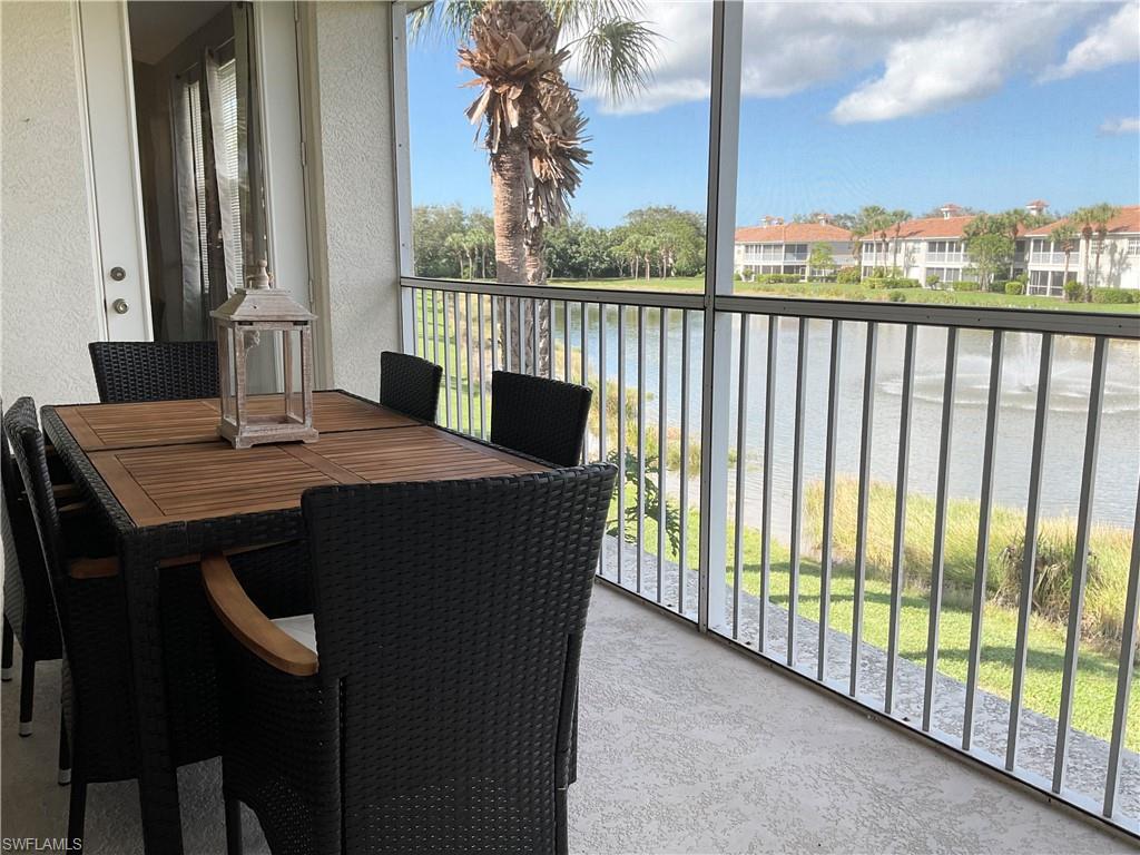 Lanai with dining area and view of lake and water feature