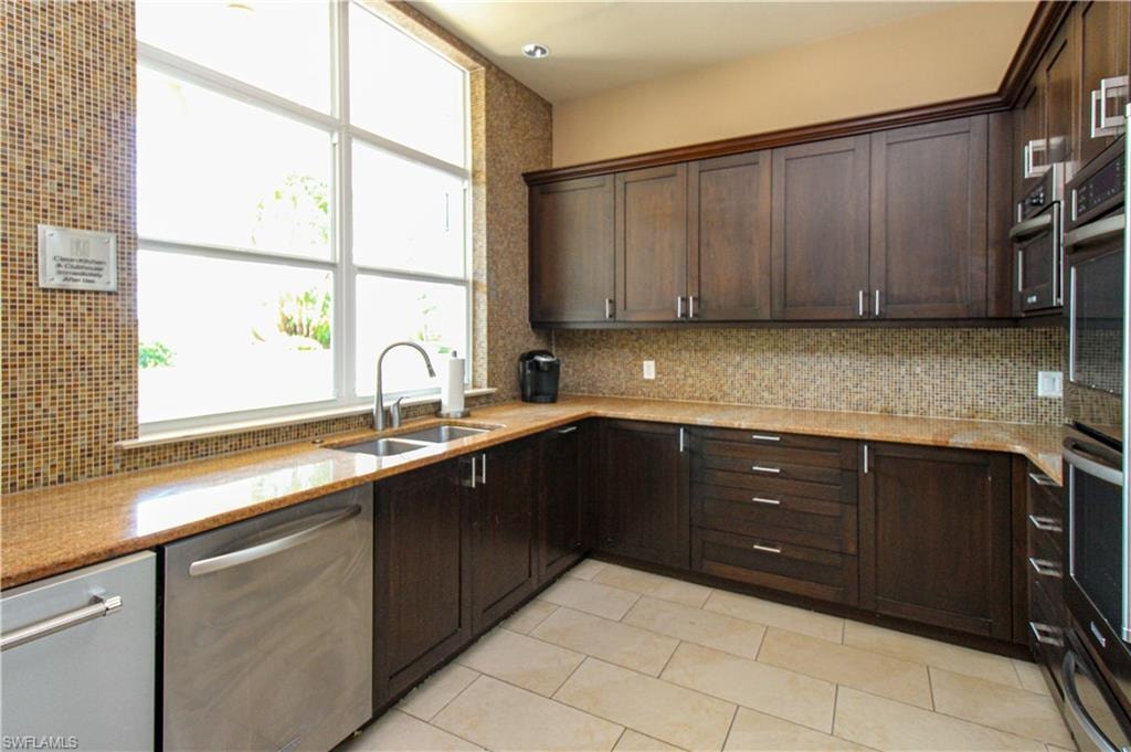 Kitchen with appliances with stainless steel finishes, sink, light tile patterned flooring, and a healthy amount of sunlight