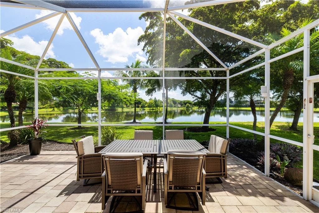 Spacious outdoor lanai with pavers surrounding by mature trees and a gorgeous lake view.