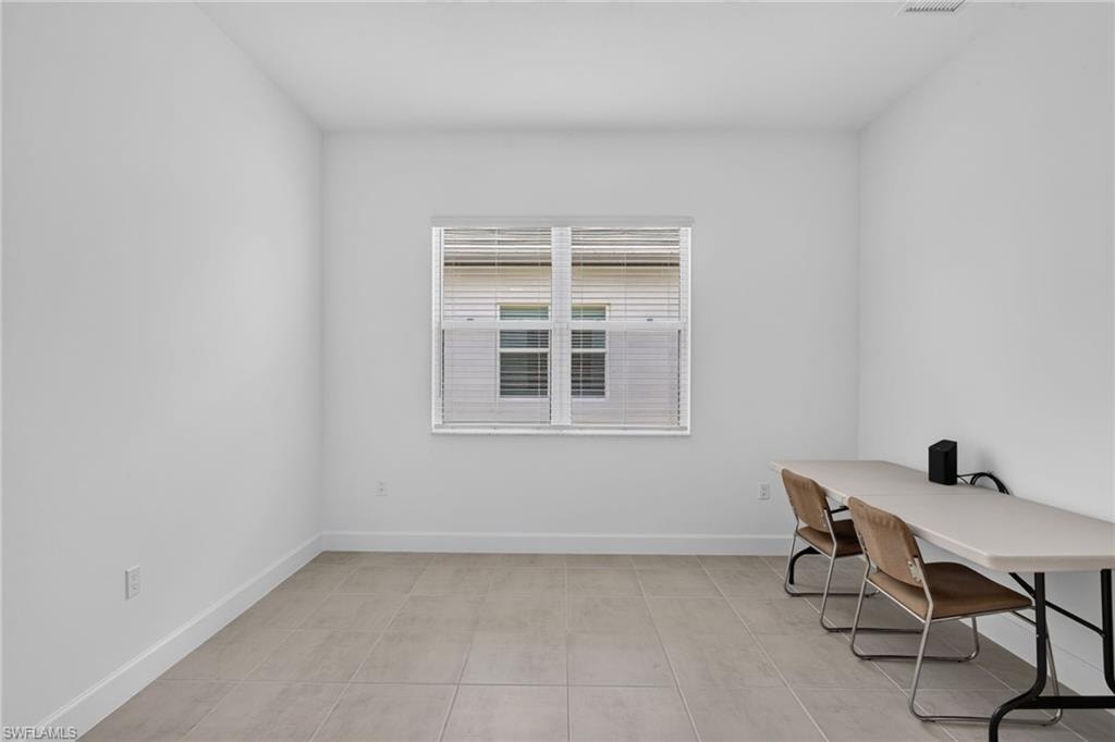 Neutral-toned ceramic tile flooring extending throughout a room featuring crisp white walls and white trim