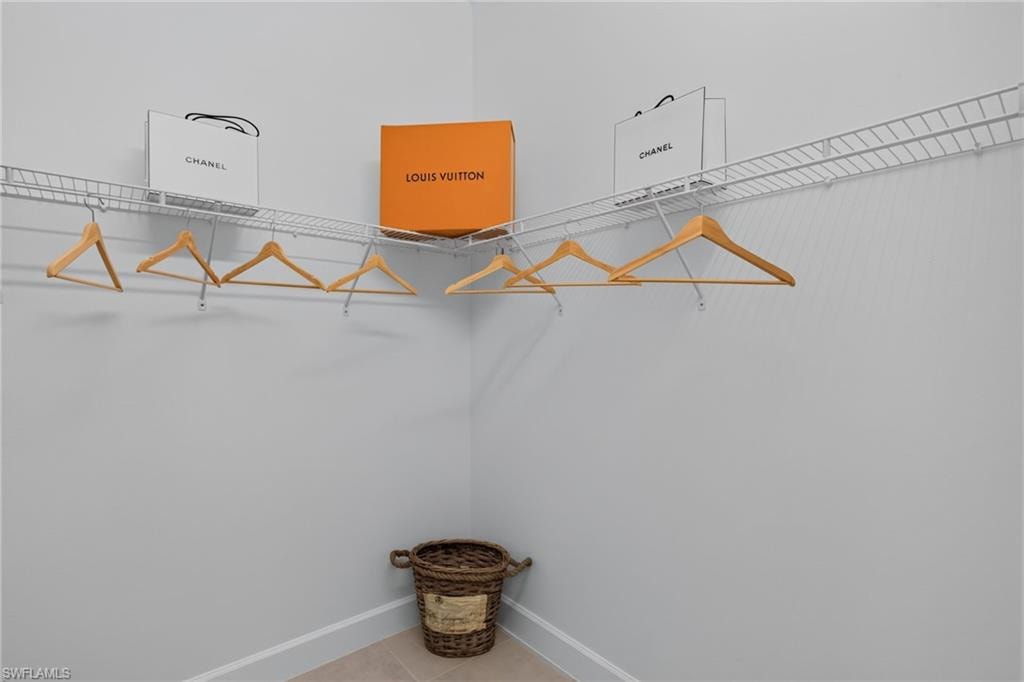 Corner closet featuring white wire shelving and hanging rods