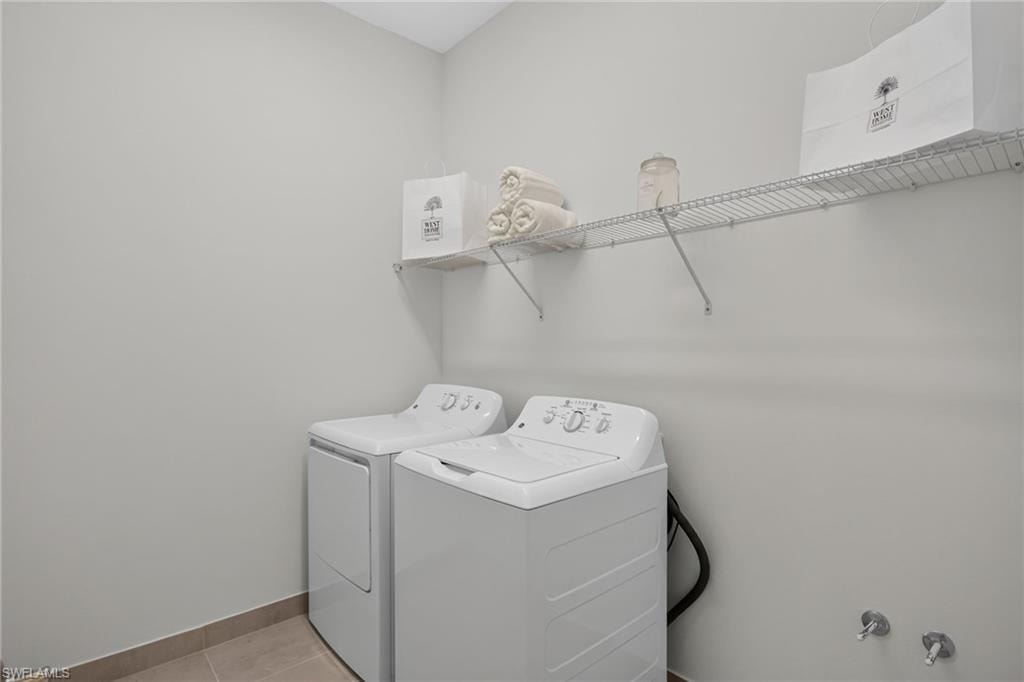 Dedicated laundry area with light gray walls, neutral-toned floor tiling, and a wire shelving system