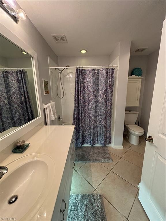 Bathroom featuring a single vanity with an integrated sink, tub with shower, toilet, and tile flooring